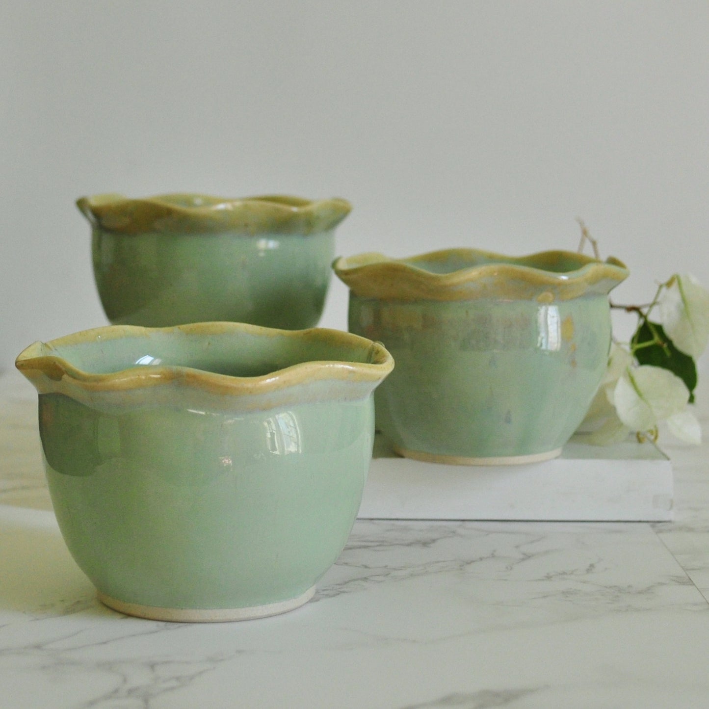 3 handmade ceramic bowls with wavy rim, made in stoneware clay and glazed in Magic Mint green glaze.