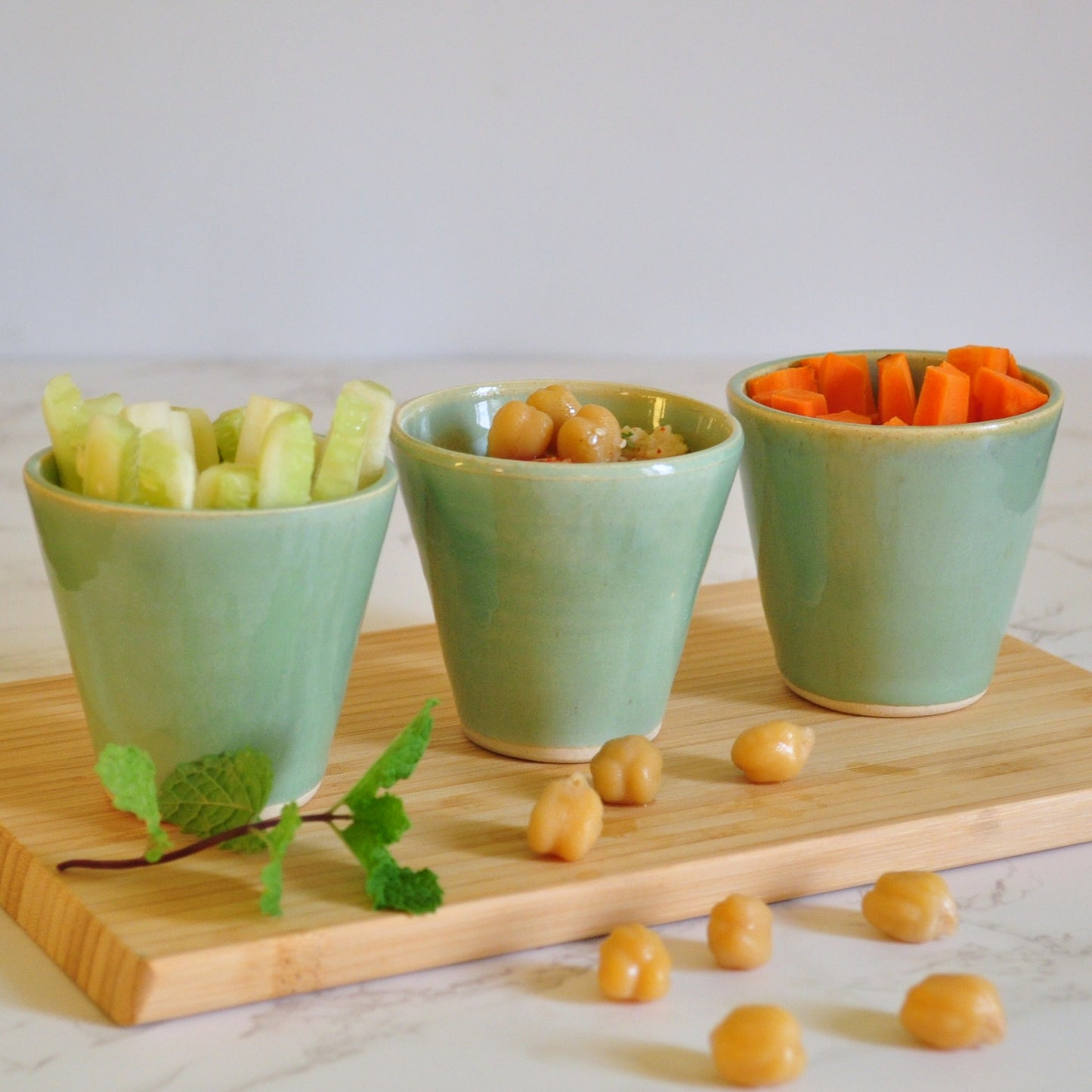 Crudites and hummus served in handmade ceramic shot glasses from Magic Mint green collection.