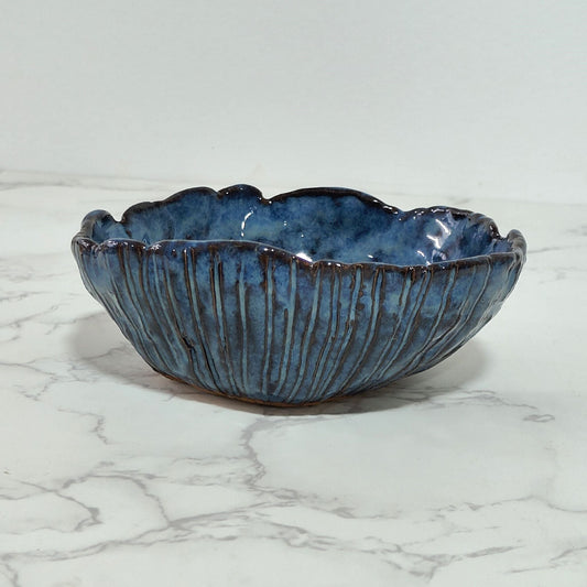 Snack bowl glazed in blue color, made using pinching technique of pottery hand-building.